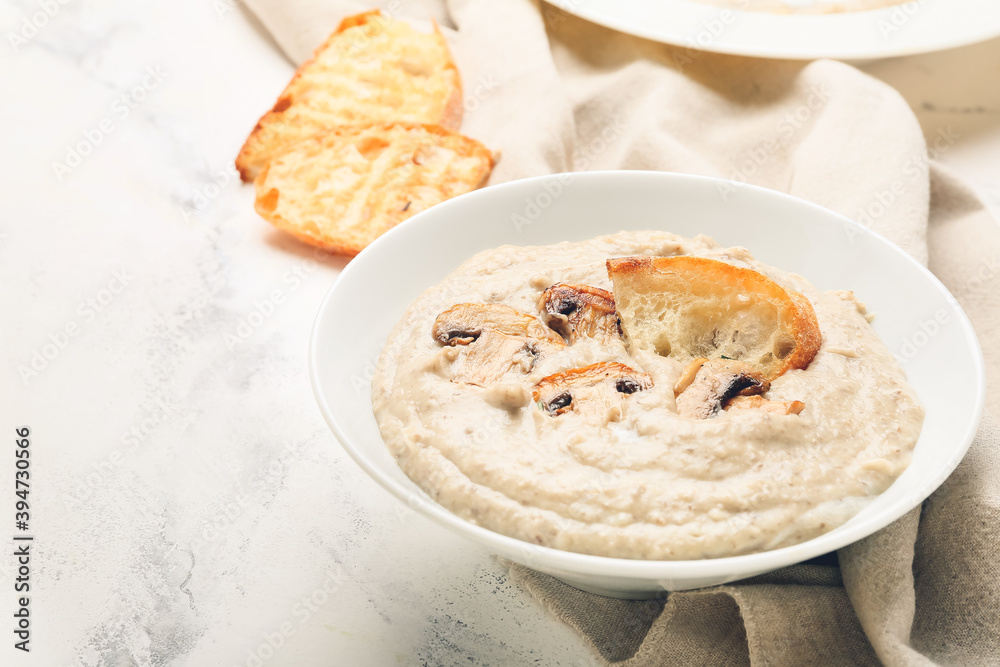 Bowl of tasty mushroom cream soup on light background Bowl of tasty mushroom cream soup on light background