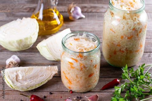 Glass jars with homemade sauerkraut on table