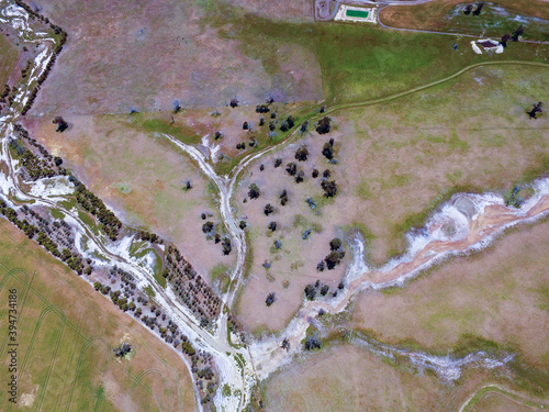 Aerial view of creek with trees and fences photo