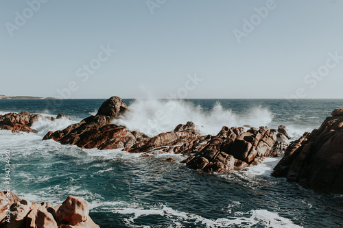 Waves crashing on rock formations just off coastline