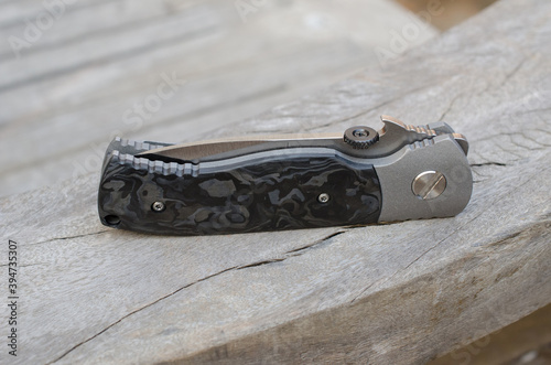 Titanium framelock folder knife with black mable carbonfiber scale. photo