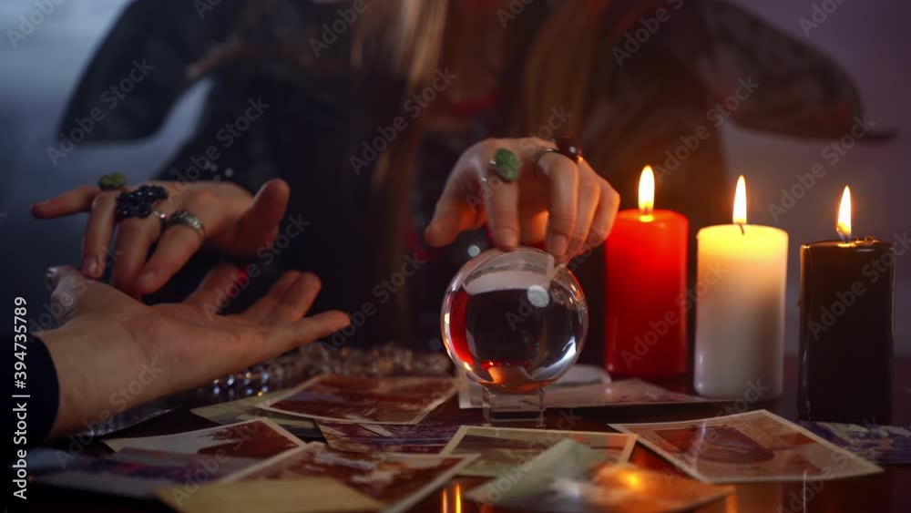 Chiromancy as a paranormal method to connect with spirits or afterlife and predict person's fate and future life. Young witch using her magic power and crystal ball for different rituals, reading fate Chiromancy as a paranormal method to connect with spirits or afterlife and predict person's fate and future life. Young witch using her magic power and crystal ball for different rituals, reading fate