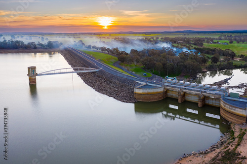 Aerial view of a water tower in a reservoir at sunset with smoke drifting across. photo