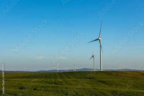 wind towers in late afternoon with farmland in foreground photo