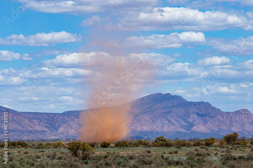 whirlwind on plains with rugged hills photo