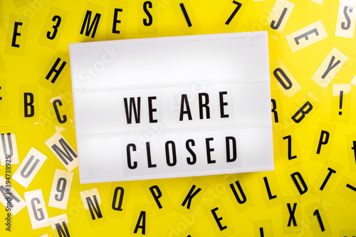 We Are Closed message on lightbox on scattered letters background of plastic alphabet Global economic crisis, quarantine due to covid-19, shutdown of restaurants and entertainment facilities concept