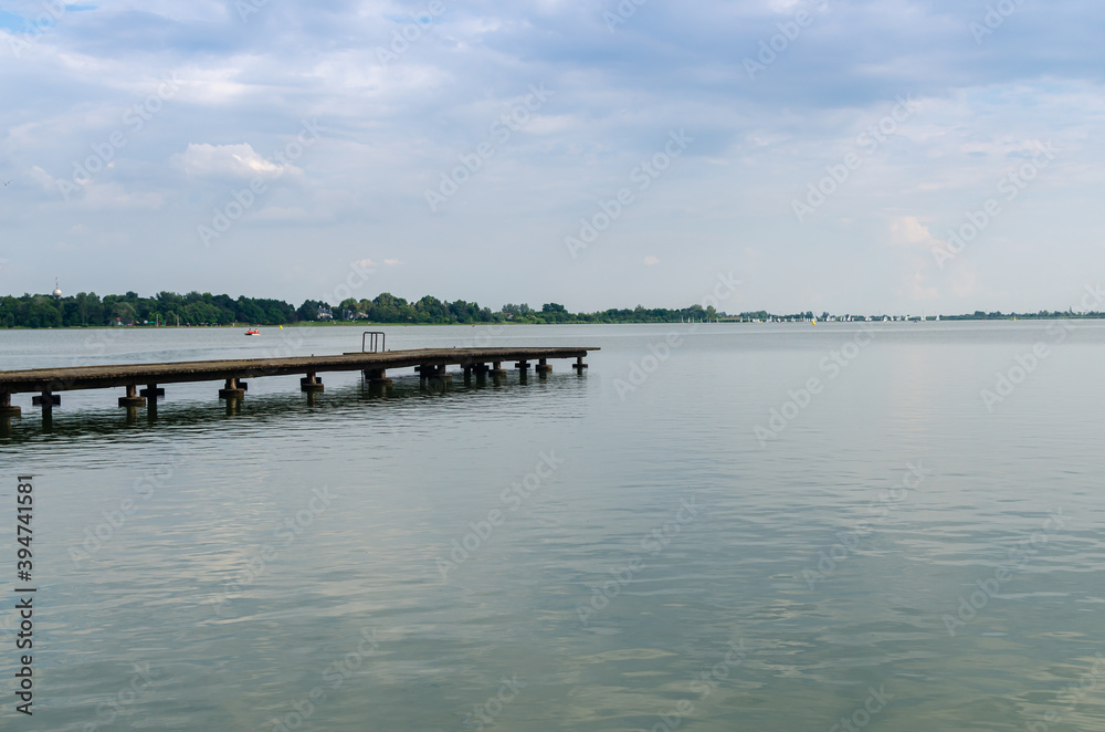 Mole in a lake with calm surface under cloudy sky