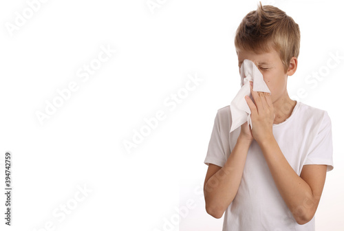 Child sneezing, Schcool boy Blowing Nose With Handkerchief isolated on white background photo