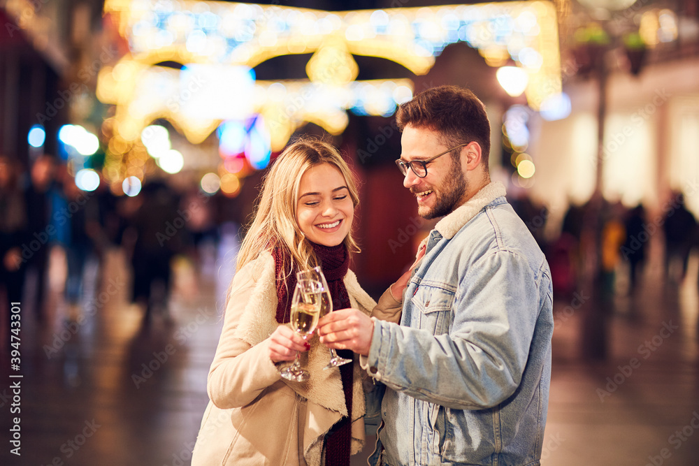 Fototapeta premium Couple drinking champagne and celebrating New Year at the street. New year party.