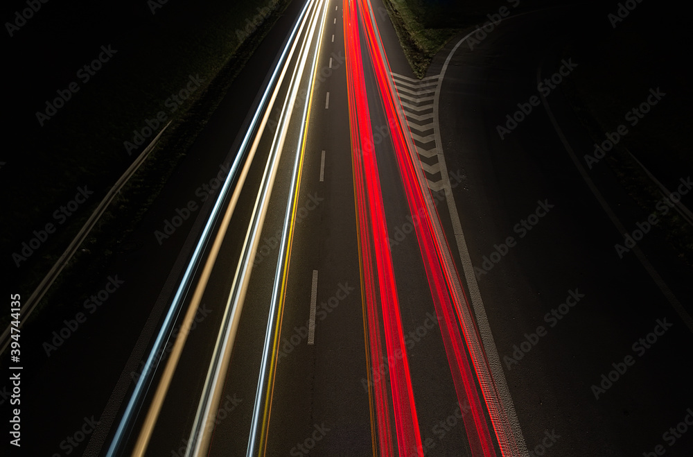 Top view of vehicle car light trails on highway road in red and white color. Trafic at night, long exposure