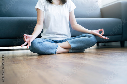 Beautiful Asian woman waking up in the morning practicing meditating exercise at home living room, routine healthy calm mind and body lifestyle spiritual mantra focus meditation lotus sitting position