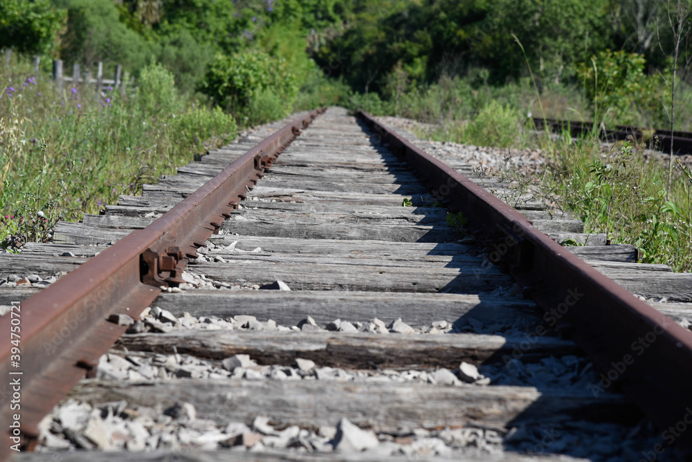 Old and abandoned railway and rails with rusty wooden sleepers in Brazil