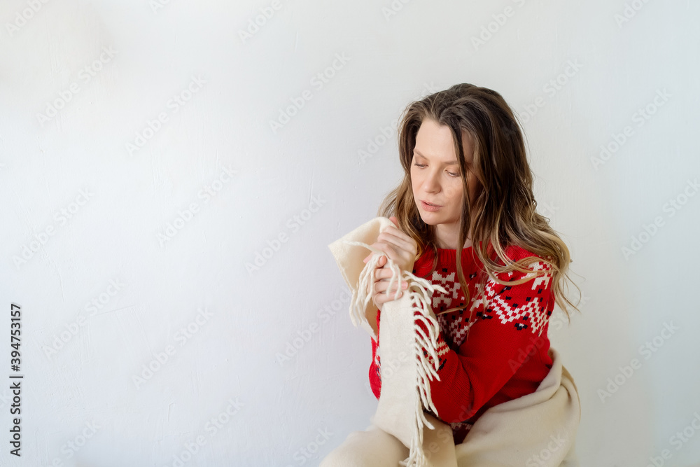A young Caucasian woman with long curly hair in a New Year's sweater is wrapped in a plaid and is freezing in the cold season. Isolated on white background
A young Caucasian woman with long curly hair in a New Year's sweater is wrapped in a plaid and is freezing in the cold season. Isolated on white background