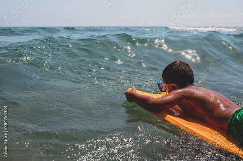 Young surfer with bodyboard on small ocean waves. photo