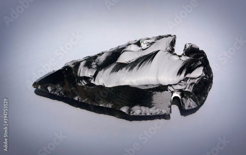 Obraz na plátně Obsidian stone arrowhead on black background