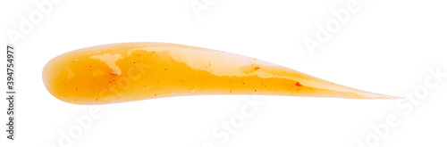 Dripping orange sauce isolated on white background. Abstract pattern made of chilli sauce. Flat lay, top view, close up.
