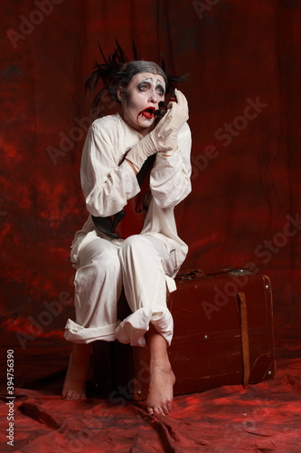 The art of depression. Studio portrait of young female actress performing as an old clown. Depresson and isolation concept photo