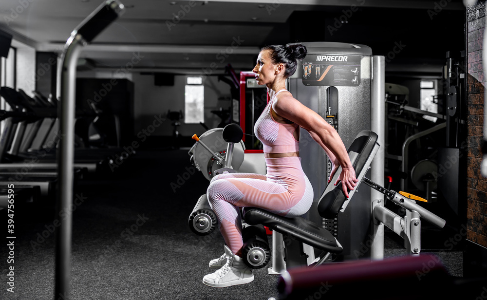 A girl in sportswear in a professional gym works out with fitness equipment. Healthy lifestyle concept A girl in sportswear in a professional gym works out with fitness equipment. Healthy lifestyle concept