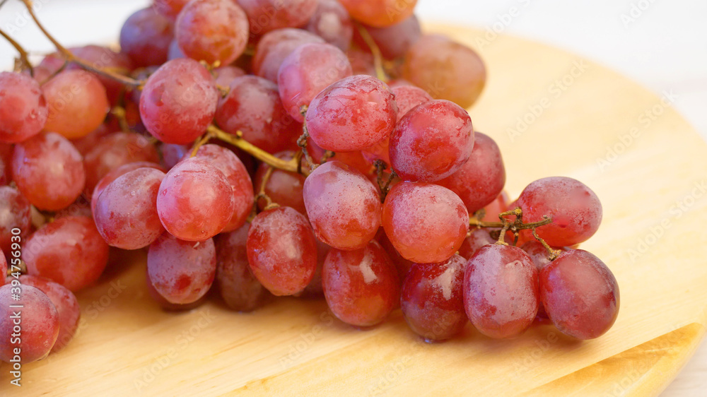 bunch of red grapes on wooden board bunch of red grapes on wooden board