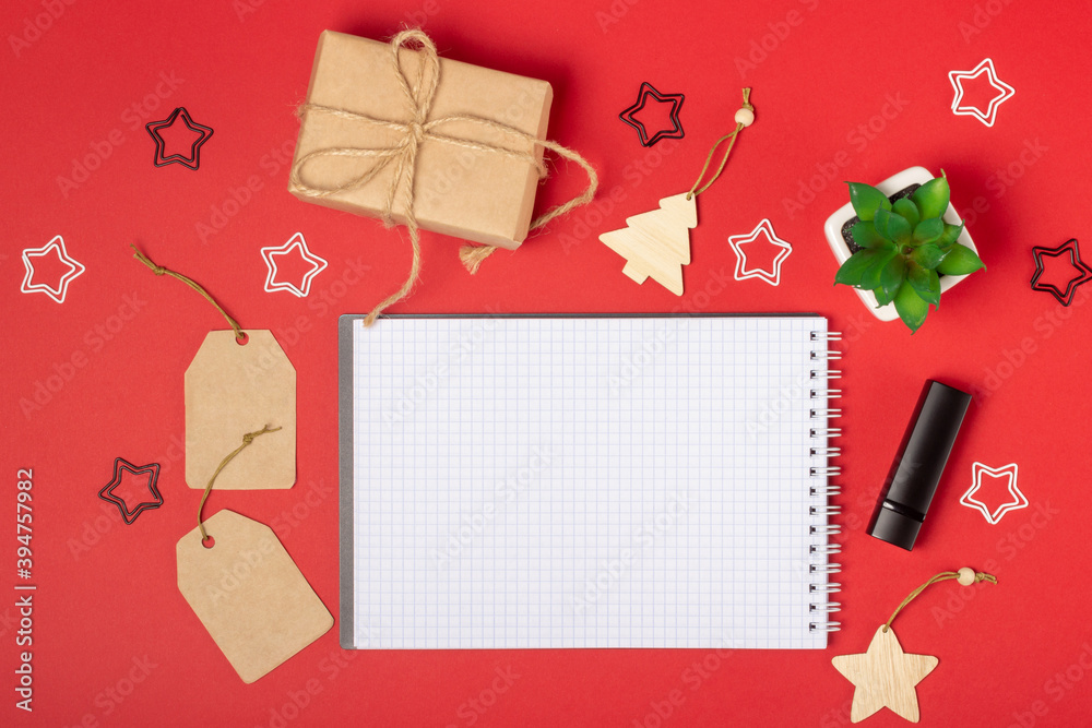 Open blank notebook with place to add text, shopping cart and boxes on a bright red background. Online shopping concept Open blank notebook with place to add text, shopping cart and boxes on a bright red background. Online shopping concept