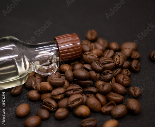 Large brown coffee beans and bottle with vanilla on white background.