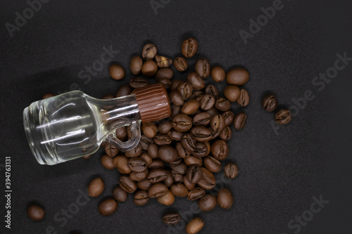 Large brown coffee beans and bottle with vanilla on white background. Top view