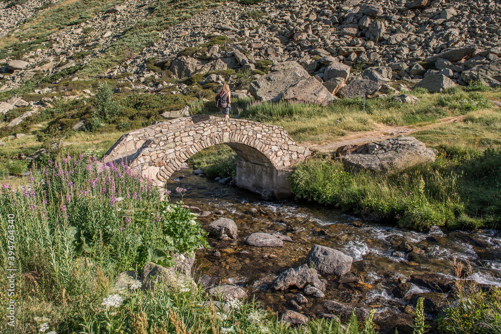 randonneur sur un vieux pont de pierre dans la montagne catalane