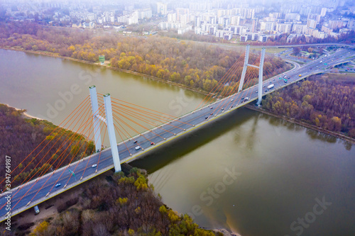 Aerial drone view. bridge in the rays of a sunny morning. Autumn haze in the air, cars are driving across the bridge.