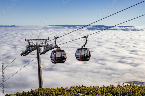 Cable cars above a dense white sea of clouds approaching Skalnate pleso, High Tatras, Slovakia photo