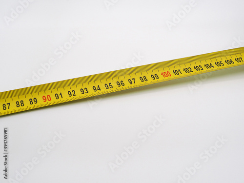 Construction roulette. Yellow ribbon with measuring scales, black and red numbers on a white background