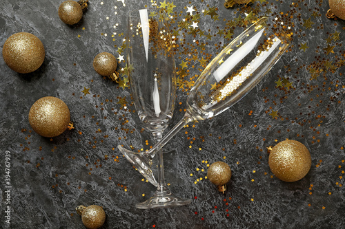 Champagne glasses, glitter and baubles on black smokey background