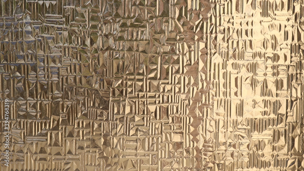 Obraz premium frosted surface of embossed opaque glass with a geometric abstract volumetric pattern, illuminated by uneven yellow light