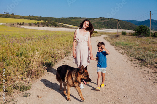 Mom and son walk with German Shepherd