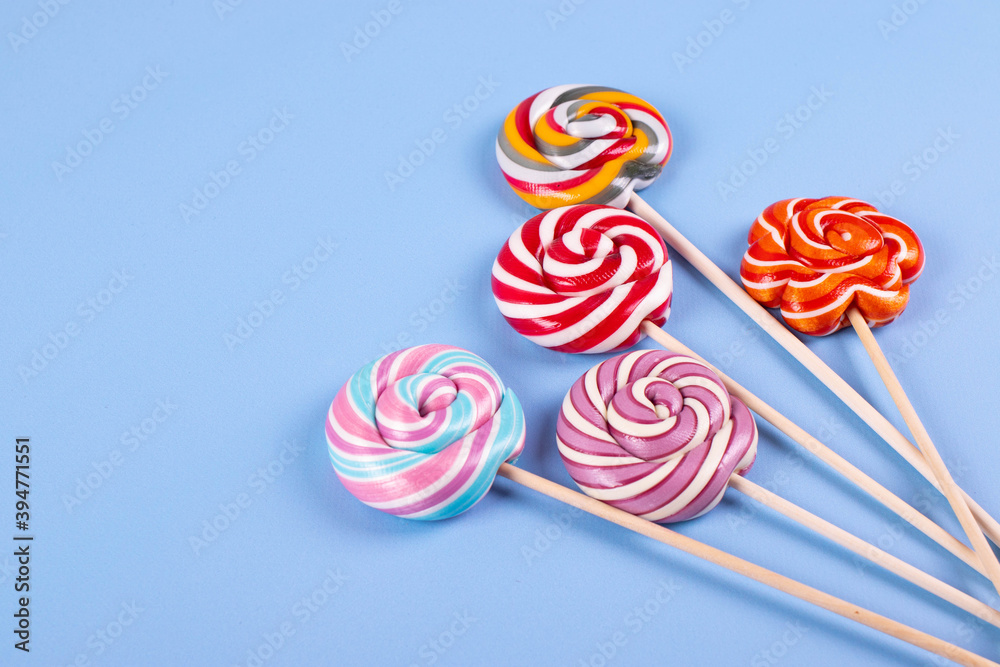 sweet yummy festive colorful lollipops on light blue background. copy space for text. minimalism style sweet yummy festive colorful lollipops on light blue background. copy space for text. minimalism style