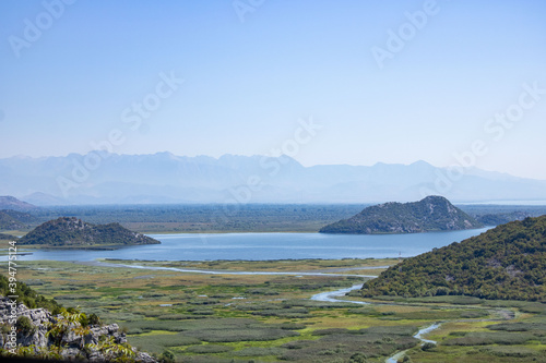 A beautiful view of the Skadar (Skoderskoe) lake among the mountains. This section of the lake is overgrown with tall grass. Montenegro. Plenty of space for text