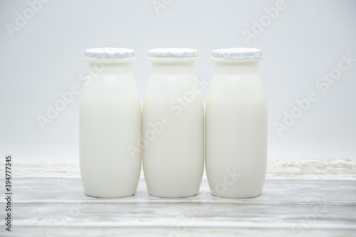 Natural liquid yogurt with probiotics in small plastic bottles on wooden table. Healthy, balanced diet food, healthy breakfast, dairy products. Selective soft focus, blurred backgroun