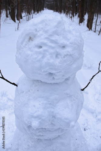 Funny snowwoman with female breast made out of snow in forest outdoors on a cold winter day