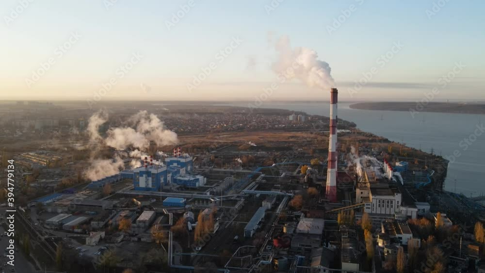 Factory chimneys producing smoke at sunrise, aerial view. Concept of air pollution, environment and ecology crisis, climate change, global warming.