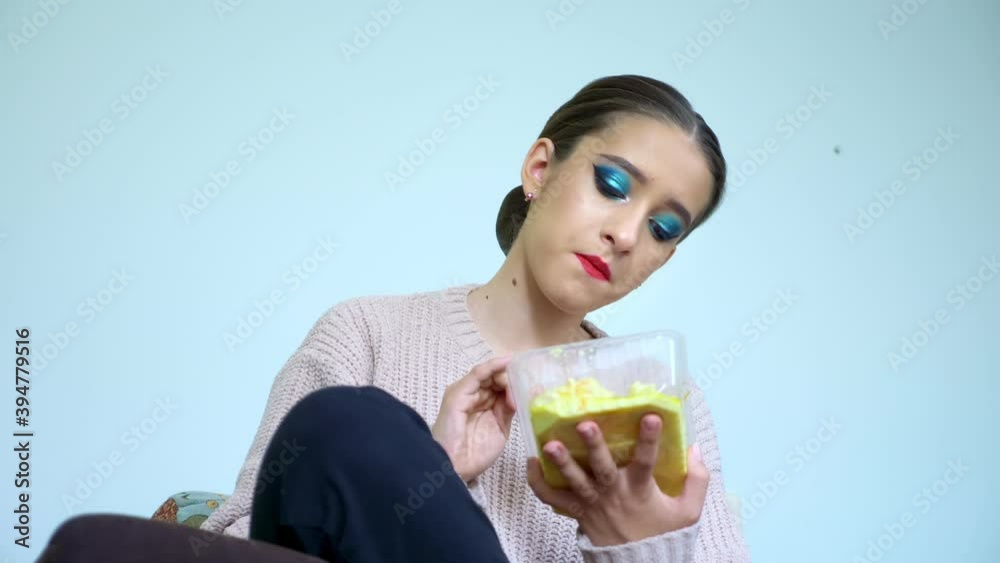 portrait of an actress girl who eats food from a container in her dressing room. portrait of an actress girl who eats food from a container in her dressing room.