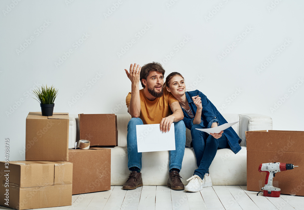 man and woman on white sofa interior cardboard boxes lifestyle man and woman on white sofa interior cardboard boxes lifestyle