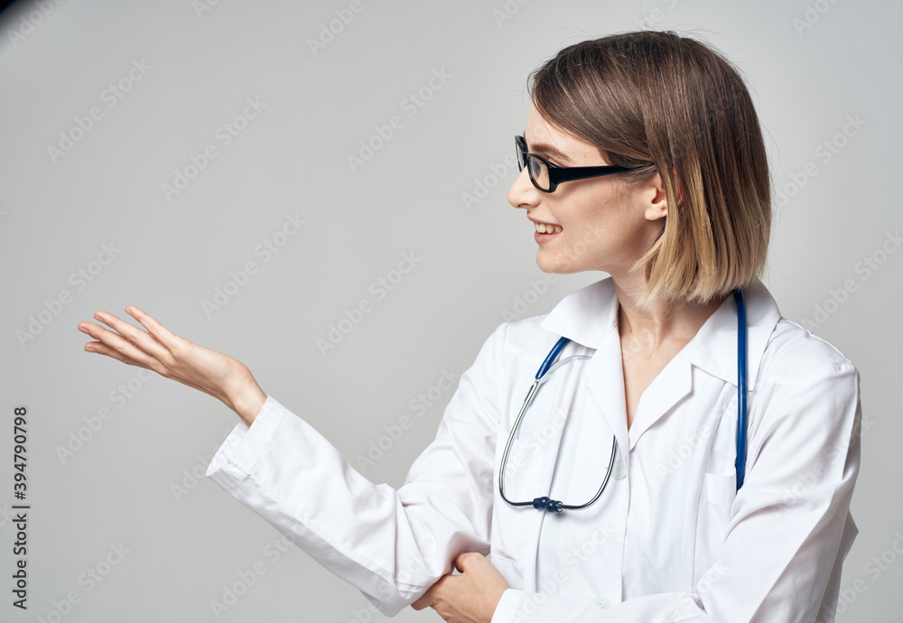 doctor with a stethoscope shows his hand to the side on a gray background Copy Space doctor with a stethoscope shows his hand to the side on a gray background Copy Space