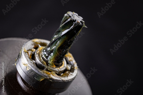 Grease lubrication of the bearing and the pin of the electric rotor. Service work of engine parts. Dark background. photo