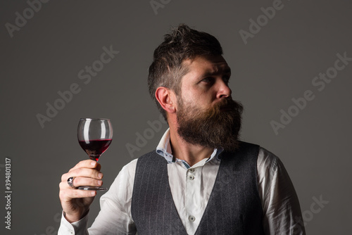 Bearded man drinks red wine. Red wine. Wine glass. Tasting alcohol. Bearded man with glass of wine.