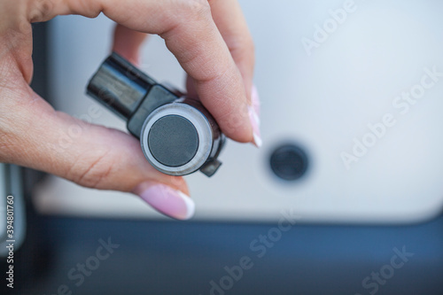girl car mechanic changes the parking sensor on the car, the sensor malfunction of parking sensors