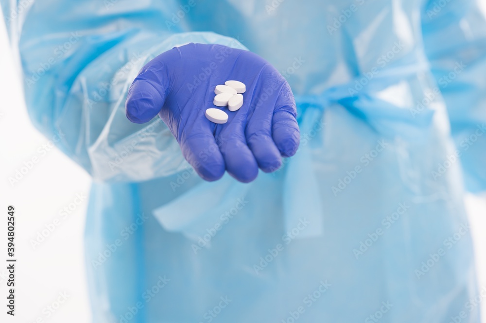 medical worker in protective costume isolated on white offer drug pills antibiotics and antipyretic from covid19 sars virus pandemic, coronavirus remedy