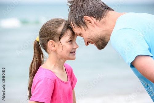 Happy dad and daughter are butting heads cheerfully