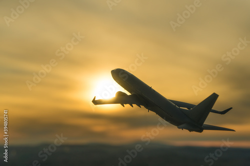 Silhouette of a plane taking off on the background of the sunset. Airline concept, travel tourism, flight. copy space