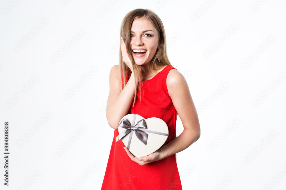 Surprised beautiful woman in a red dress with a gift box touch face. Surprised beautiful woman in a red dress with a gift box touch face.
