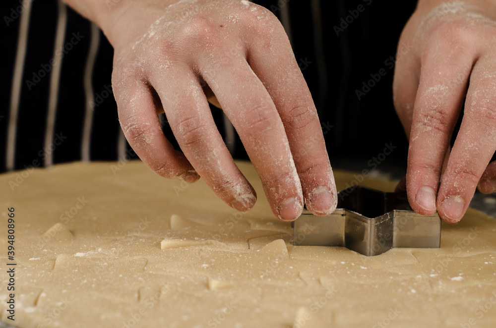 manos cortando galletas de navidad en forma de estrella 