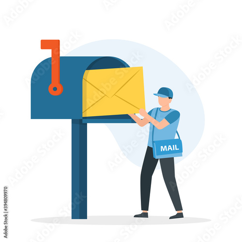 Man postman with bag on shoulder put letter in mail box.
